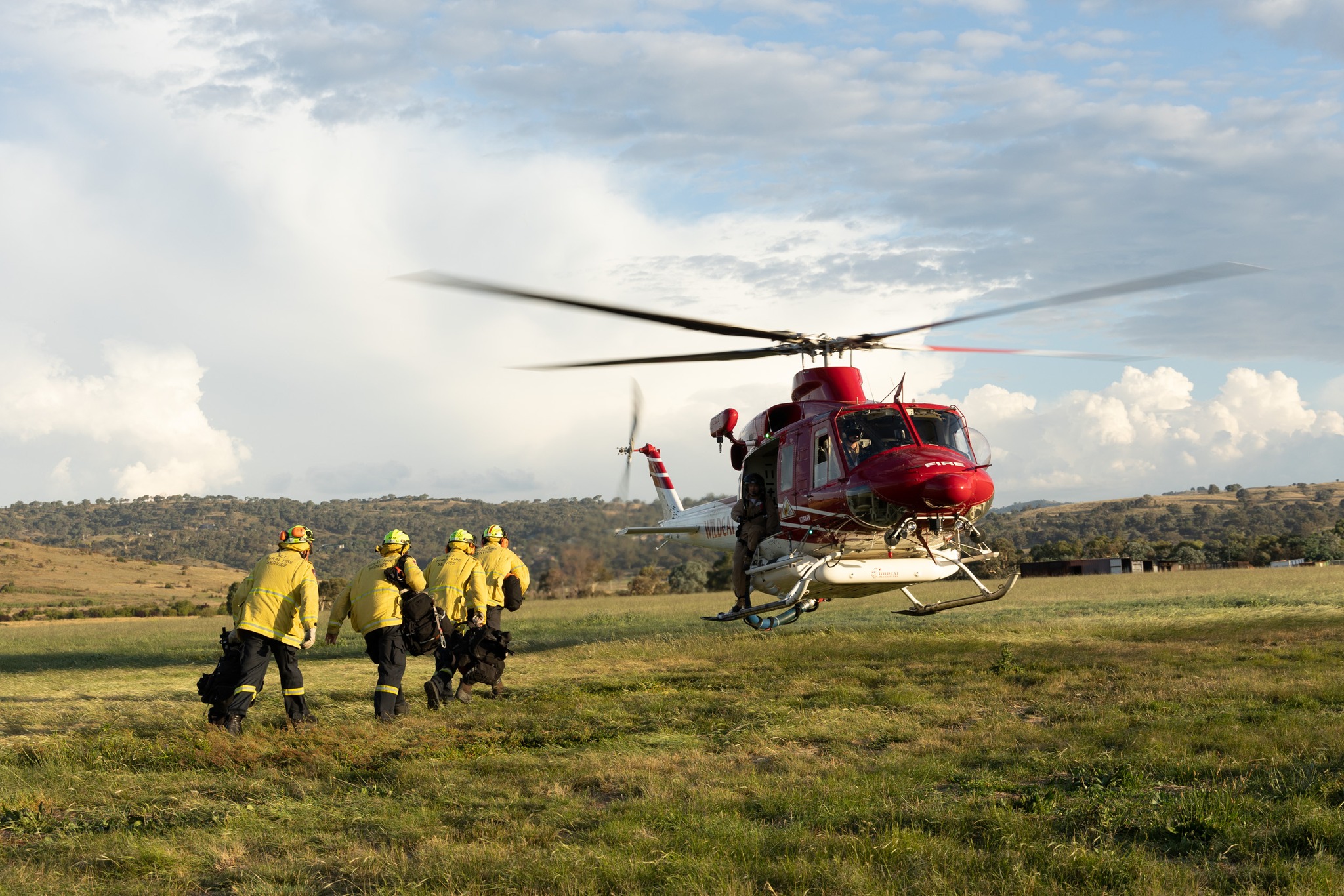 Firefighters heading towards a helicopter to board it