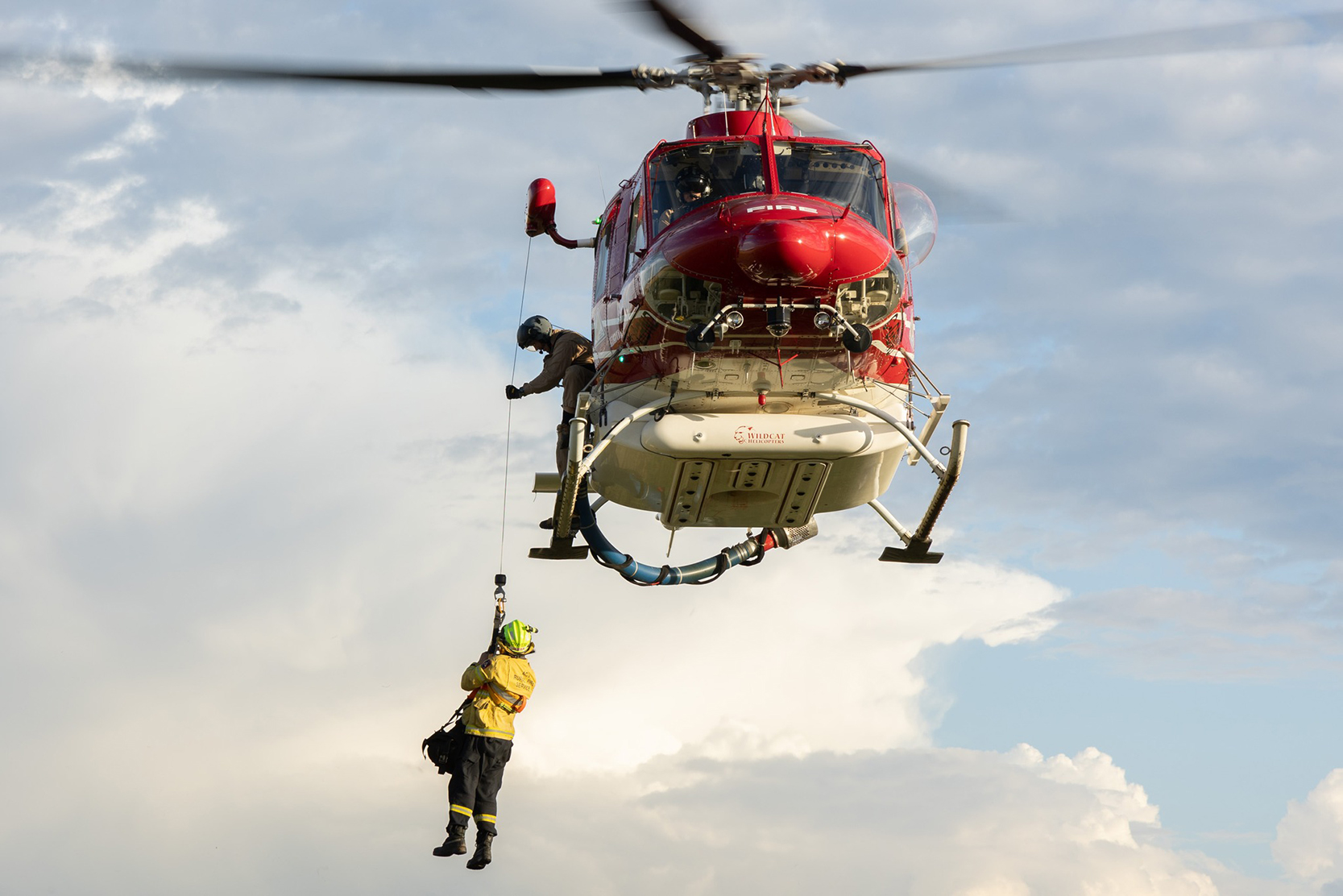 A firefighter being airlifted on to a helicopter